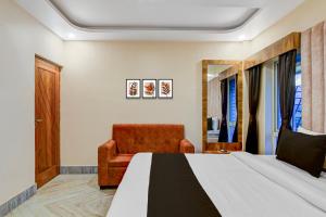 una camera da letto con un letto e una sedia di Hotel O AAHELI RESORT a Calcutta Altre 21 foto