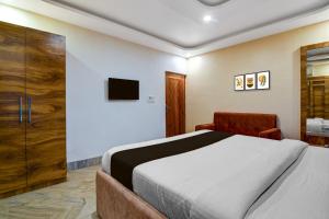 una camera da letto con un letto e una TV a parete di Hotel O AAHELI RESORT a Calcutta