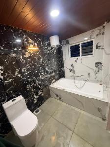 um banheiro preto e branco com um vaso sanitário e uma banheira em le hut residency em Pondicherry