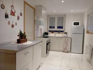 a kitchen with white cabinets and a white refrigerator at Appartement in Kesseldorf