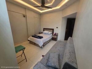 een slaapkamer met een bed en een bank erin bij Star Residence in Karachi