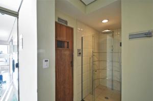 a bathroom with a door open and a shower stall at Transamerica Executive Paulista in São Paulo