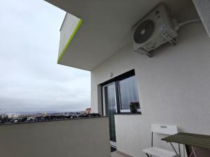 a room with a balcony with a fan and a window at Home Ready in Sibiu