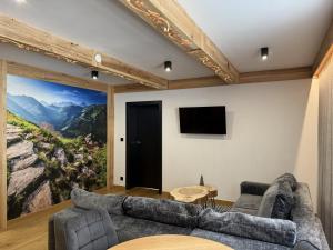 ein Wohnzimmer mit einem großen Gemälde an der Wand in der Unterkunft GreenHill Bachleda in Zakopane