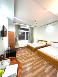 迪石Nhà Nghỉ Thành Đạt - Bến Tàu Phú Quốc的有两张床和一张书桌的酒店房间