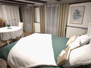 a bedroom with a bed and a table with a table at Studio La Maison des Suedois in Saint-Pierre-Bois +3 photos