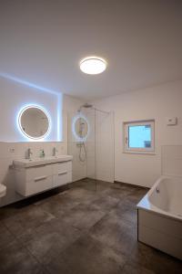 a bathroom with two sinks and a tub and a shower at betterplaces Homes - Frontenhausen in Frontenhausen +11 photos