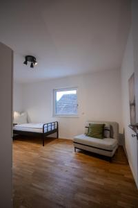 a room with a couch and a bed and a window at betterplaces Homes - Frontenhausen in Frontenhausen