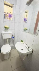 een witte badkamer met een toilet en een wastafel bij adtek homes Room PENDO in Nairobi