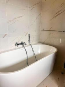 eine weiße Badewanne mit einem Wasserhahn im Bad in der Unterkunft Seaview stay at Cinnamon Life Residence - City of Dreams in Colombo