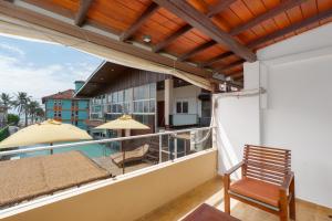 a balcony with a view of the pool and a chair at Beach Corridor Hotel & Spa with Free Airport shuttle in Negombo