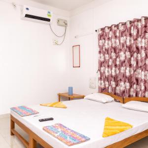 马尔万Mahapurush Nyahari Niwas的一间卧室配有两张床和窗帘