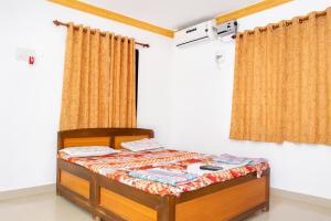 马尔万Mahapurush Nyahari Niwas的配有窗帘的客房内的小床