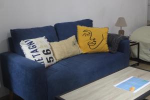 a blue couch with pillows on it with a table at Le Ty Logis in Vannes +1 photo
