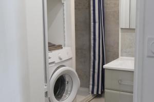 a bathroom with a washing machine and a sink at Le Ty Logis in Vannes