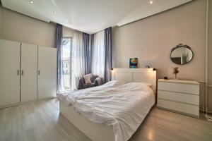 a bedroom with a white bed and a mirror at Heart of Sofia 2 Bdr Elevator Balcony Relax in Sofia