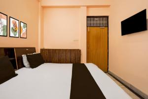 勒克瑙Hotel O Chandra banquets的一间卧室配有两张床、一台电视和一扇门 更多21张照片