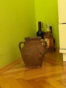an old vase sitting on the floor next to bottles at KMB suite in Nikšić