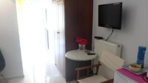 a room with a table and a tv on a wall at Summer Holidays Studio in Chania