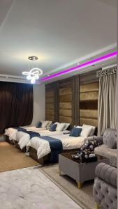 a large bedroom with three beds and a couch at نيروز بارك in Najran