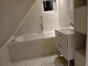 a white bathroom with a tub and a sink at Appartement in Kesseldorf +12 photos