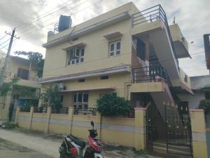 a house with a scooter parked in front of it at Tanvi Guest House Hampi in Hampi +12 photos