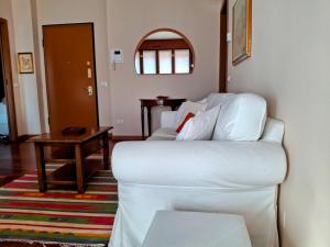 a living room with a white couch and a table at Casa Mike - Trilocale con garage in San Giuliano Milanese +22 photos