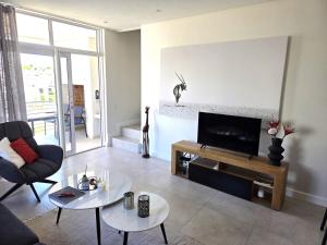 a living room with a flat screen tv on a wall at Casa Voliere in Stellenbosch
