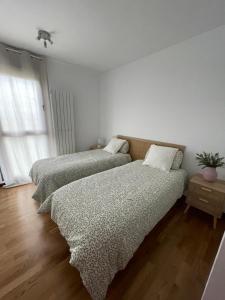 Un dormitorio con dos camas y una ventana. en Casa acogedora golf Rioja alta, en Cirueña 7 fotos más