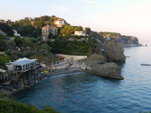 a view of a beach with houses on a cliff at Park Hotel in Albisola Superiore