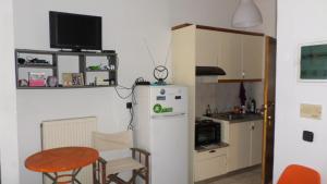 a kitchen with a small table and a refrigerator at Summer Holidays Studio in Chania