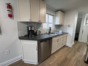 a kitchen with white cabinets and a black counter top at North Barrie !E Stylish and Cozy Private Bedroom with Shared Bathroom in Barrie