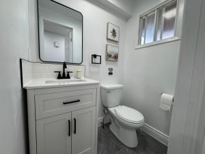 a white bathroom with a toilet and a mirror at North Barrie !E Stylish and Cozy Private Bedroom with Shared Bathroom in Barrie