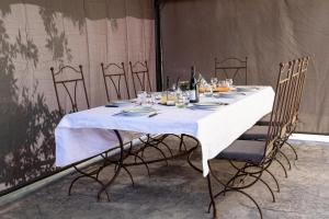 a table with a white tablecloth and chairs with wine bottles at Gîte de Prestige dans un Fort, Jacuzzi, 8 pers in Leynhac