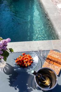 a table with a bowl of tomatoes and a bottle of wine at Gîte de Prestige dans un Fort, Jacuzzi, 8 pers in Leynhac +45 photos
