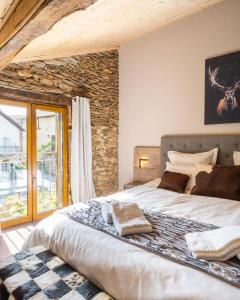 a bedroom with a large bed and a stone wall at Gîte de Prestige dans un Fort, Jacuzzi, 8 pers in Leynhac +45 photos