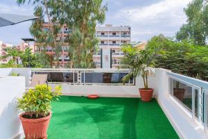 un balcone di un appartamento con pavimento verde e piante in vaso di Jaara Home - High standing and luxurious 2-bedroom apartment - Maristes a Dakar