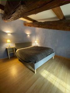 una camera da letto con un letto in una stanza con soffitti in legno di maison familiale a Saint-Trinit