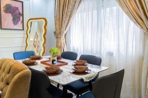 una sala da pranzo con tavolo, sedie blu e tavolo di Jaara Home - High standing and luxurious 2-bedroom apartment - Maristes a Dakar