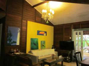a living room with a white couch and a yellow wall at Pousada das Gêmeas in Ilha do Mel
