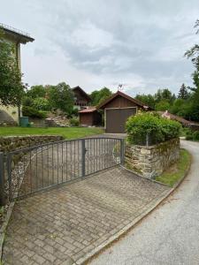 a metal gate on a brick walkway next to a house at Ferienhaus am Schloss in Tittling
