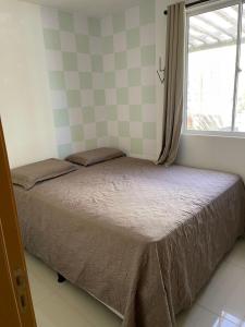 Una cama pequeña en una habitación con ventana. en Apartamento completo próximo à praia de ponta negra, en Parnamirim