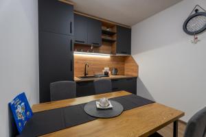 a kitchen and dining room with a table with a hat on it at 108 Lux Apartman Ravna planina in Gornje Pale