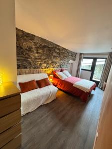 sypialnia z 2 łóżkami i kamienną ścianą w obiekcie Les Écrins d'or - Maison Les Deux Alpes w mieście Les Deux Alpes +49 zdjęć