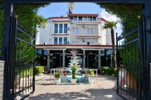 a gate with a christmas tree in front of a building at Hotel Bardhi in Kuçovë