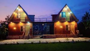 uma casa grande com luzes na frente em Amangarh Corbett Farmstay em Rehar