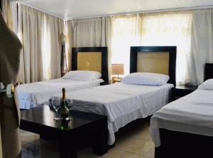 a hotel room with two beds and a table at Hotel Bardhi in Kuçovë