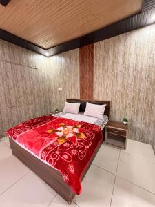 um quarto com uma cama grande com um cobertor vermelho em Amangarh Corbett Farmstay em Rehar