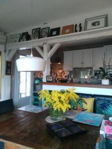 een keuken met een tafel met gele bloemen erop bij Maison individuelle avec piscine privée in Peyruis