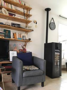 een woonkamer met een stoel en een televisie bij Maison individuelle avec piscine privée in Peyruis